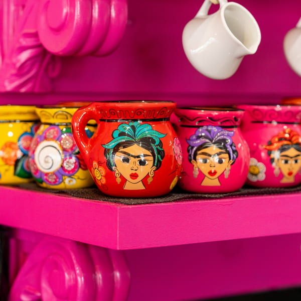 Colorful Mexican mugs with Frida Kahlo's face on a bright pink shelf at Mexico Lindo Restaurant.