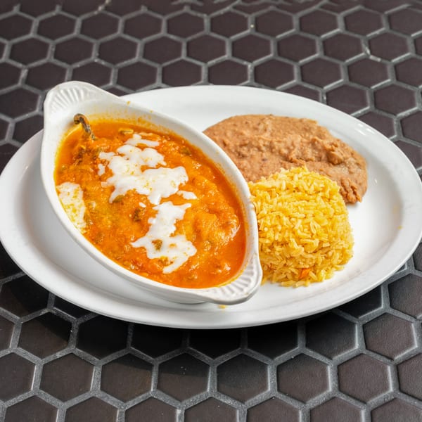 Chile Relleno with melted cheese, rice, and refried beans on a white plate at Mexico Lindo Restaurant.