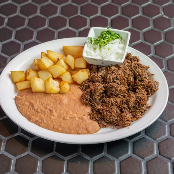 Shredded beef, refried beans, and diced potatoes with a side of onions and cilantro.